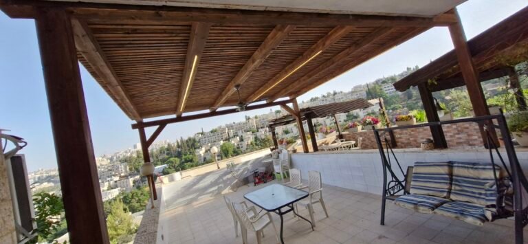 פרגולת עץ עם תאורת לד, נדנדה ופינת ישיבה במרפסת עם נוף