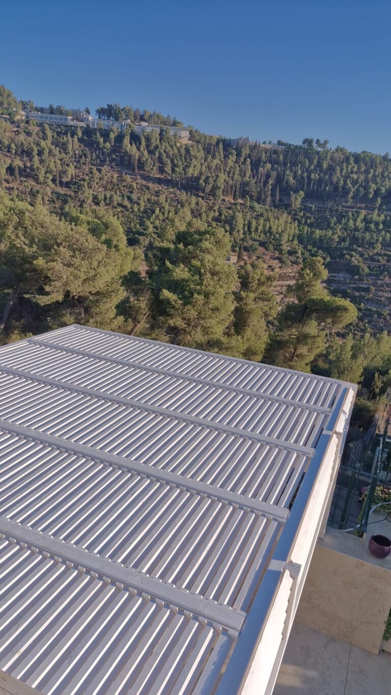 פרגולה לבנה עם שלבים, מבט מלמעלה מול נוף יער
